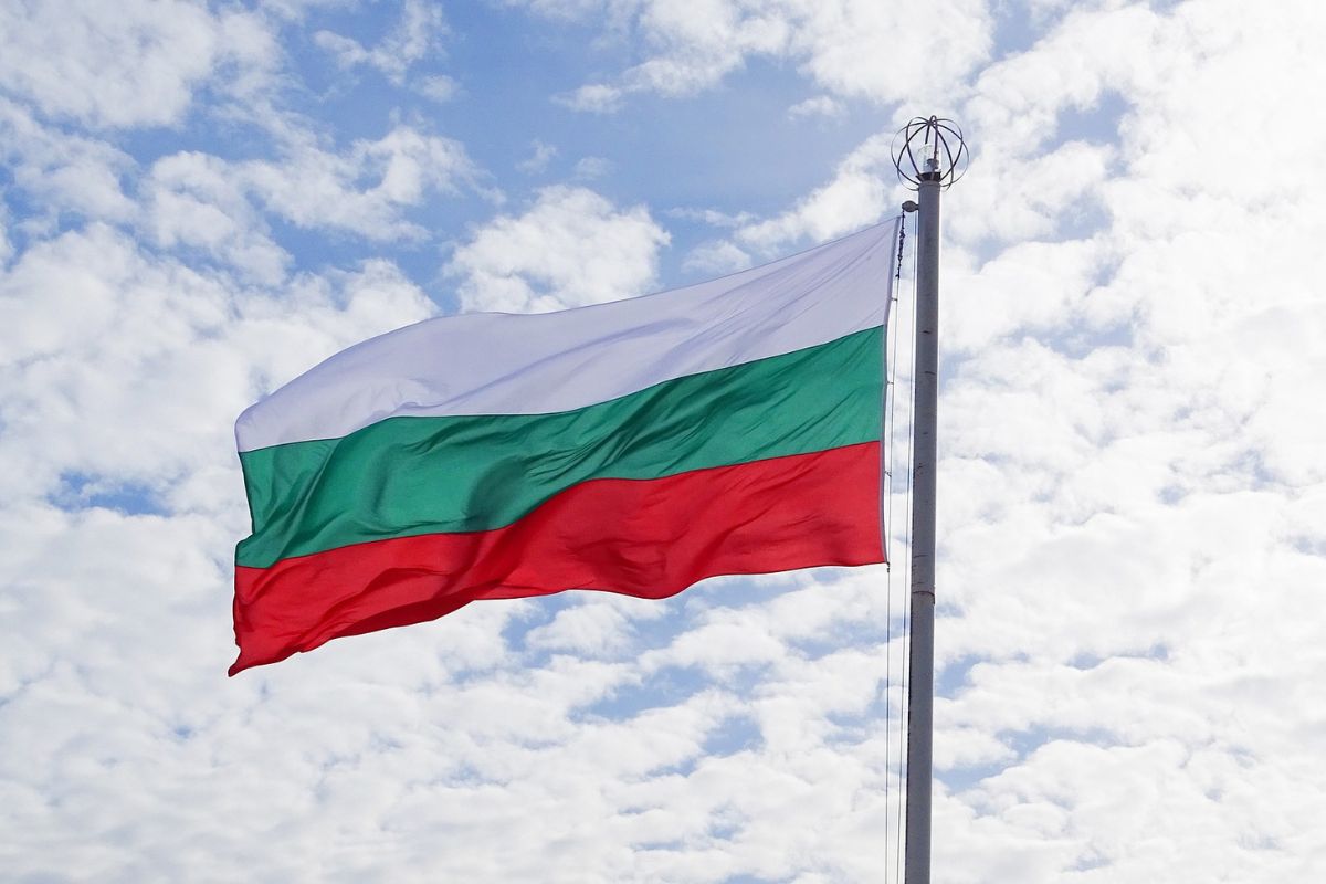 Powiewająca flaga bułgarska na tle chmur.