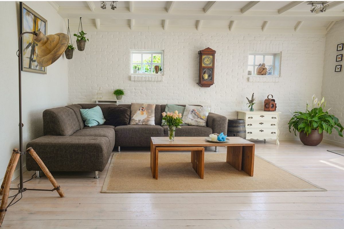 Widok na wnętrze pokoju, z lampą stojącą, kanapą narożną, stołem kawowym, komodą itp.