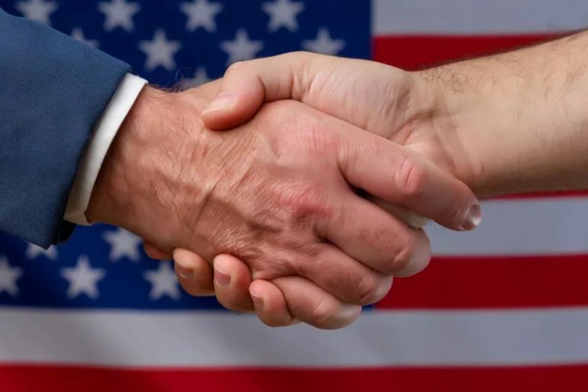 uścisk dłoni na tle flagi USA