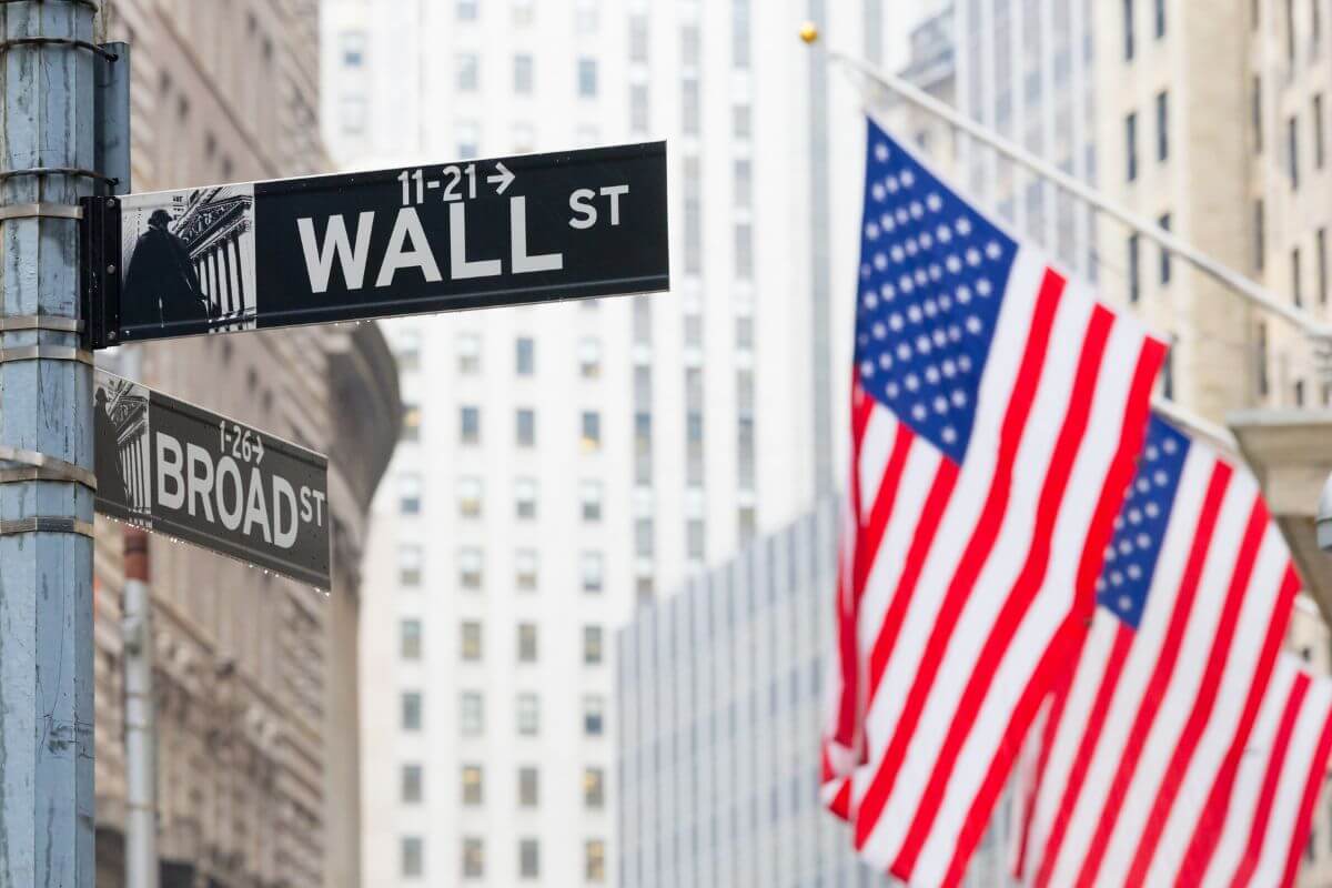flaga amerykańska i szyld nazwy ulicy wall st
